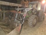 un tracteur garé sur la terre battue près d'une clôture