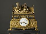une horloge en or sur laquelle sont représentés un homme et une femme