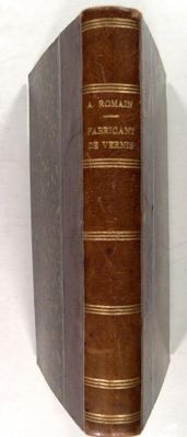 un livre marron posé sur une table blanche