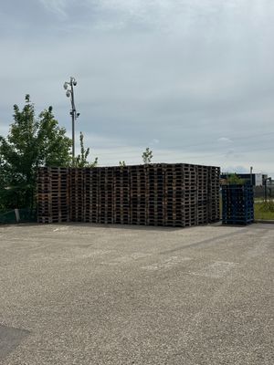 de nombreuses palettes empilées sur un parking
