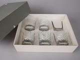 une boîte contenant six verres, posée sur une table