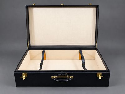 une valise noire munie de deux poignées et d'une poignée noire