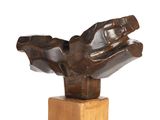 statue of a hand holding a glove on a wooden base