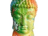 a statue of a buddha head with graffiti on it ' s face