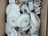a box full of white and pink dishes and cups