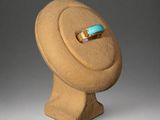 sculpture of a hat with a turquoise stone ring on top of it
