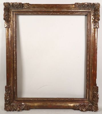 a gold ornate frame with a white wall behind it