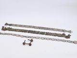 trois bracelets en argent et une bague posés sur un fond blanc