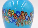 a blue vase with flowers on it on a white surface
