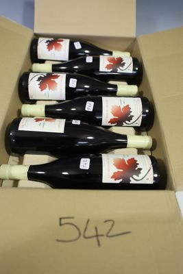 six bottles of red wine in a cardboard box on a table