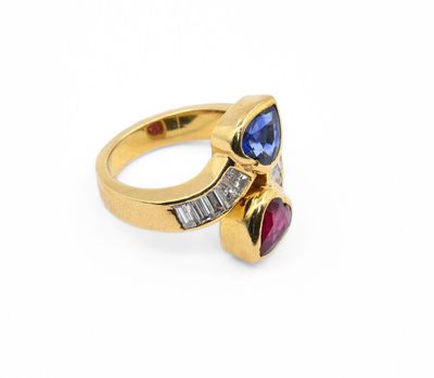 un gros plan d'une bague en or sertie de pierres bleues et roses