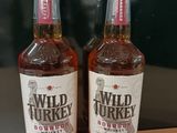 deux bouteilles de bourbon Wild Turkey posées sur une table en bois