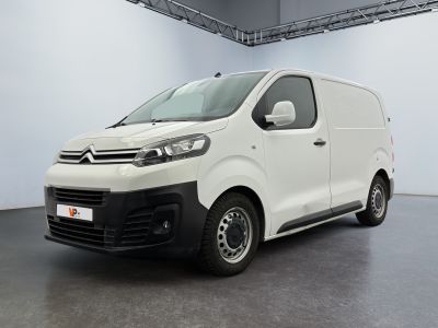 La camionnette blanche est garée dans la grande salle du bâtiment.