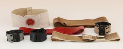 a belt, belt, camera, and other items on a white surface
