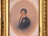 portrait of a gentleman in a black suit with a gold frame