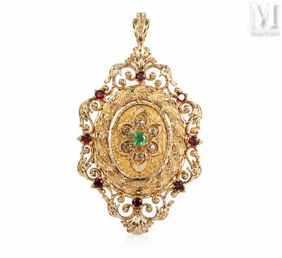 a close up of a gold pendant with a green and red stone
