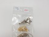 a close up of a bag of metal hooks on a white surface