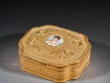 une boîte en or ancien sur laquelle figure l'image d'une femme