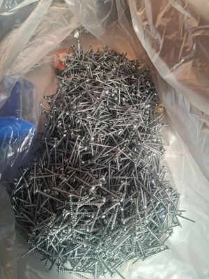 a pile of nails in a plastic bag on a table