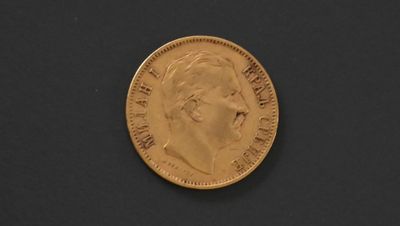 a close up of a gold coin on a black surface