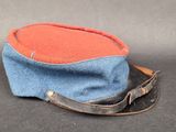 un chapeau bleu et orange muni d'un cordon en cuir