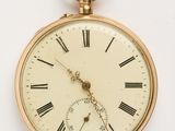 une montre de poche en or avec des chiffres romains sur le cadran