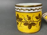 a yellow and white cup and a bowl on a table