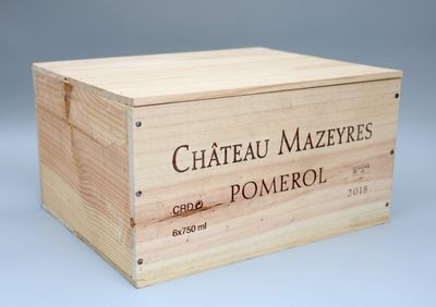 une photo d'une caisse en bois sur laquelle est accrochée une étiquette indiquant « Château Mazerre - Pomerol »