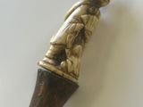 un petit bâton en bois surmonté d'une statuette