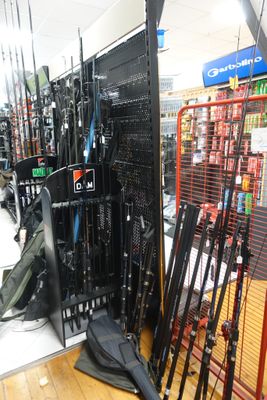 de nombreux modèles de cannes à pêche exposés dans un magasin