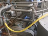 a large tank with a yellow hose next to it