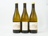 trois bouteilles de vin posées sur une table blanche