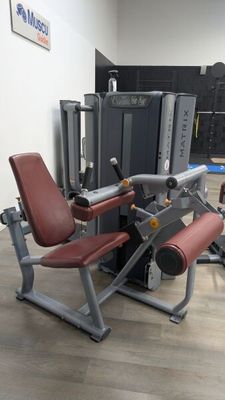 an image of a gym room with a machine and a bench