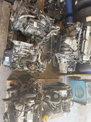 de nombreuses pièces de moteur éparpillées sur le sol d'un garage