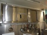 de nombreuses casseroles et poêles accrochées au mur de la cuisine