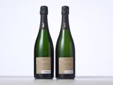 two bottles of champagne sitting next to each other on a table