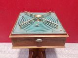 an old wooden box with a fan on top of it