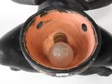 a black statue with a light bulb in it ' s mouth