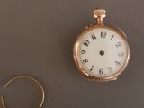 une montre en or et une bague en or posées sur une table