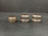 three silver cups sitting on top of a table next to each other