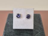une paire de boucles d'oreilles en saphir bleu posées sur un bloc de marbre