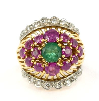 a close up of a ring with a green and purple stone surrounded by diamonds
