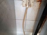 a broken electrical outlet on the ceiling of a bathroom