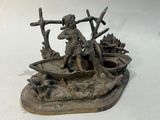 une statue représentant un homme dans un bateau, posée sur une surface blanche