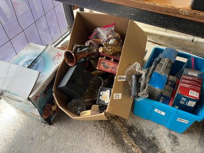 une boîte remplie d'objets hétéroclites posée sur le sol