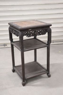 une petite table surmontée d'une étagère, placée devant une porte de garage