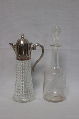 une petite bouteille en verre à côté d'une petite carafe en verre
