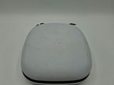 the back of a white device with a black button on it