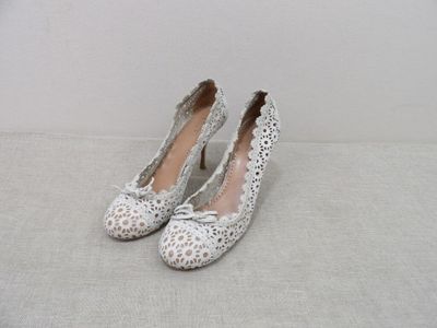 paire de chaussures pour femme, blanches et argentées, ornées de nœuds sur le bout
