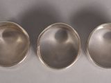 three silver spoons sitting on top of a table next to each other